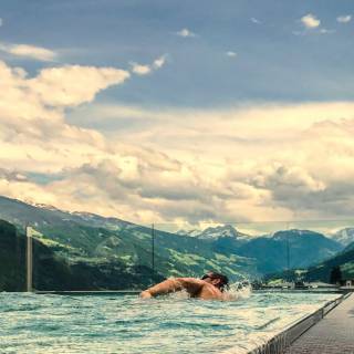 Mann schiwimmt im Infinity-Skypool im Mia Alpina