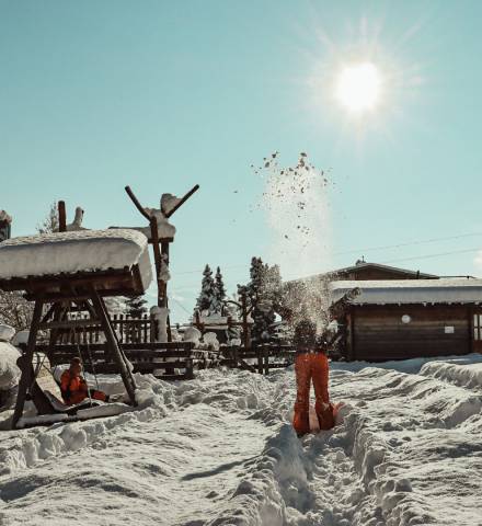 Kinder spielen im Schnee im Hof des Mia Alpina